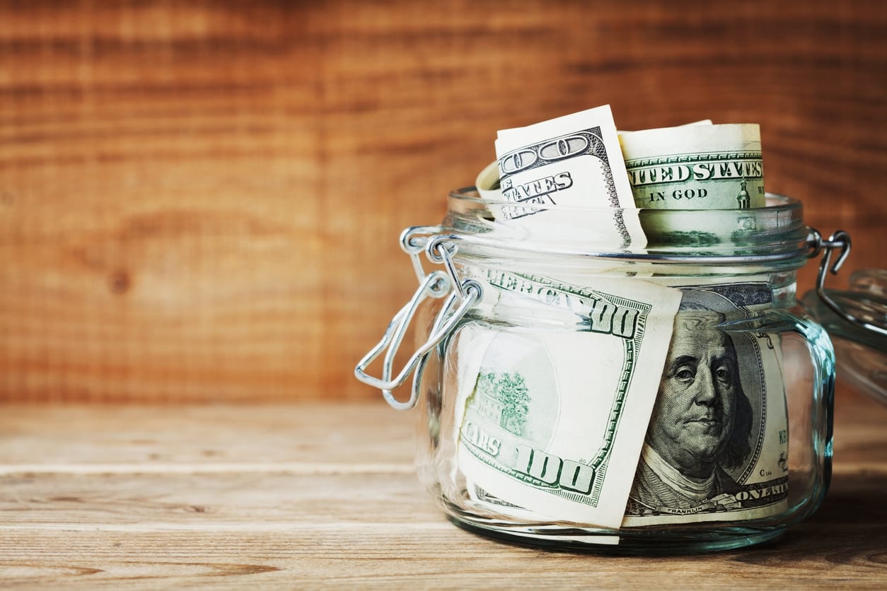 Dollar bills in glass jar. Saving money and finance concept.