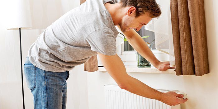Man adjusting radiator temperature.
